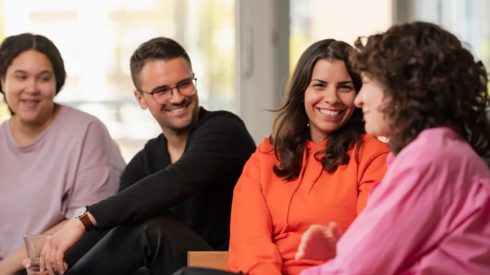 Arbeitskolleg:innen sitzen zusammen und lachen